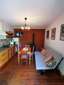 a kitchen and dining room with a table and a couch at Leszczynowy Sad - apartament z kominkiem i ogrodem in Wydminy