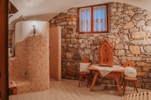 a bathroom with a table and chairs and a stone wall at Ansitz Gurtenhof in Tesimo +75 photos