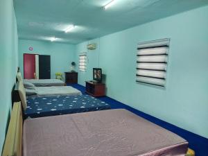 two beds in a room with blue walls at Village House With River View And Karaoke 8 to10 Pax in Jeram