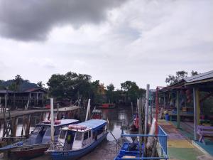 two boats are docked at a dock on the water at Village House With River View And Karaoke 8 to10 Pax in Jeram
