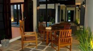 The Luxio Hotel في سورونغ: طاولة طعام وكراسي خشبية في الغرفة