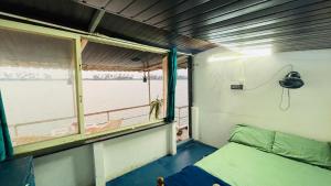 a room with a bed and a window on a boat at Palm Breeze in Udupi +3 photos