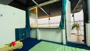 a room with a window and a bed in a room at Palm Breeze in Udupi