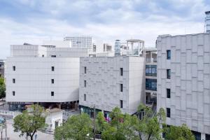 ein großes weißes Gebäude in einer Stadt in der Unterkunft JI Hotel Shanghai Xuhui Riverside in Shanghai