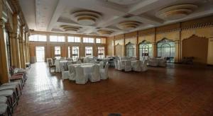 Grand Norling Hotel's Resort في Baudhatinchule: غرفه كبيره فيها طاولات بيضاء وكراسي +156 صورة