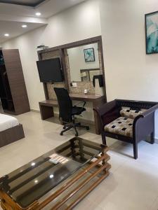 a living room with a bed and a desk and a chair at Hotel Solitaire in Ambāla Cantonment +20 photos