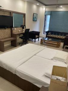 Un dormitorio grande con una cama y un piano. en Hotel Solitaire, en Ambāla Cantonment