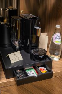 a black blender sitting on a counter with a bottle of water at Hotel Brilliant Plaza in Zalău +104 photos