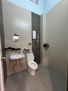 un baño con inodoro y lavabo en 峇株巴辖皇子城现代简约风格民宿, en Tongkang Pechah 8 fotos más