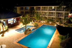 uma piscina em frente a um hotel à noite em The Melanesian Port Vila em Port Vila