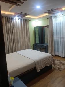 a bedroom with a bed and a dresser and a television at Le Petit Paradis Nepal Terrace & Mountain View in Pātan +28 photos