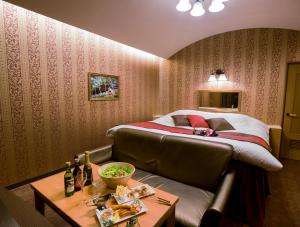 um quarto de hotel com uma cama e uma mesa com bebidas em Kumamoto Hotel Christmas Forest Garden (Love Hotel) em Shimo-koga