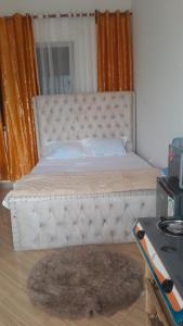 Little Haven في ماليندي: غرفة نوم بها سرير ذو إطار أبيض وسجادة