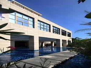 Man Wan Harmona Resort في Youcaopeng: مبنى امامه مسبح