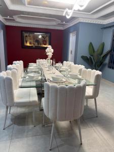 De Rams boutique guest house : غرفة طعام مع طاولة طويلة وكراسي بيضاء