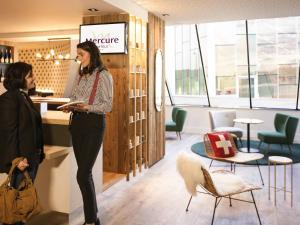 Dos mujeres de pie en un mostrador de una tienda en Mercure Chambéry Centre, en Chambéry