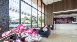 a lobby with purple furniture in a building with windows at Viva Residence in Ban Baen Phichit