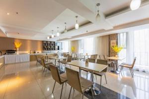 a dining room with tables and chairs and a kitchen at City Comfort Inn Wuhan Baibuting in Wuhan