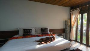 um quarto com uma cama com lençóis brancos e uma janela em The Banana Cottage em Udawalawe mais 7 fotografias