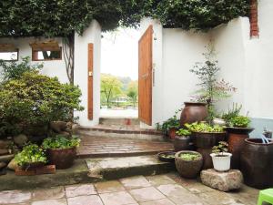 a porch with potted plants and an open door at Mua Guesthouse in Namwon
