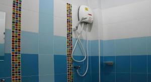 a shower in a bathroom with blue and white tiles at Sabai Ez Hotel in Songkhla