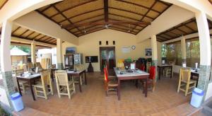 a restaurant with tables and chairs in a room at Mustika Ocean Lodge in Gili Islands