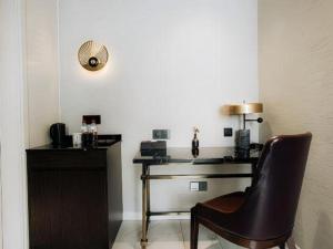 a chair sitting next to a desk with a fan at Jinjiang Metropolo Hotel Nanjing Jiangning Binjiang Development Zone in Qingxiu