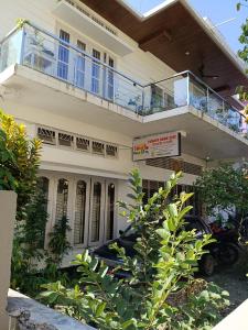 Tomato home stay في Tezpur: منزل أبيض مع شرفة فوقه