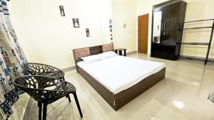 Tomato home stay في Tezpur: غرفة نوم بها سرير وكرسي +5 صور