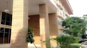 a building with columns and plants in front of it at Amarin Grand Hotel in Ban Choeng Noen