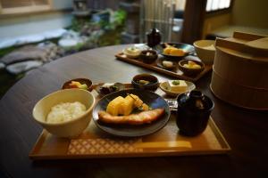 une table avec une plaque de nourriture et une plaque de riz dans l'établissement Ryokan Tori, à Kyoto