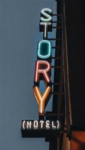 a neon sign for a hotel with a trash can on it at STORY HOTEL STOCKHOLM STUREPLAN, in JdV by Hyatt in Stockholm
