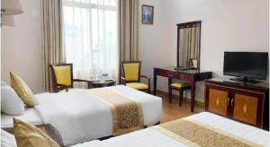 a hotel room with two beds and a desk and a television at Cong Doan Viet Nam Hotel in Hanoi