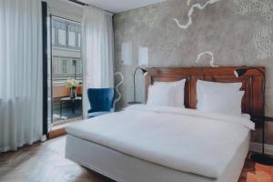 a bedroom with a large white bed and a window at STORY HOTEL STOCKHOLM STUREPLAN, in JdV by Hyatt in Stockholm