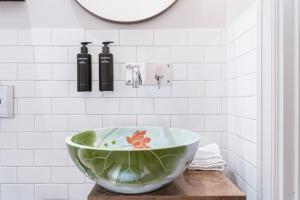 a green bowl on a counter in a bathroom at STORY HOTEL STOCKHOLM STUREPLAN, in JdV by Hyatt in Stockholm