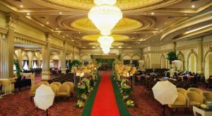 a large banquet hall with a red carpet and chairs at Grand Qin Hotel Syariah in Martapura +235 photos
