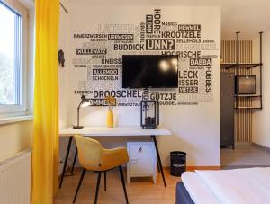 Hotel Restaurant Litermont في Nalbach: غرفة نوم مع مكتب وتلفزيون على الحائط