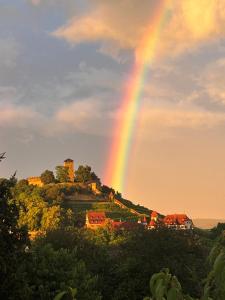 a rainbow over a house on a hill with a castle at Burgblick Stube - Apartment für bis zu 4 Personen - Haustiere willkommen - mit Einbauküche - Fahrradparkplatz etc in Beilstein