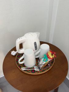 Una tetera y tazas en un plato sobre una mesa. en Season Bungalow, en Ko Jum