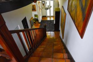 a hallway with a staircase with paintings on the walls at At Wind Chimes Boutique Hotel in San Juan