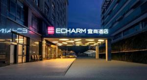 a building with a lit up sign on the side of it at Echarm Hotel Xiamen Airport Huojuyuan Metro Station in Xiamen