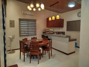 a kitchen and dining room with a wooden table and chairs at Matthew's Tranquil Homestay in General Luna