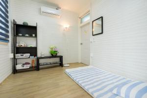 Habitación con alfombra azul y pared blanca en Yours Guesthouse in Tongyeong, en Tongyeong