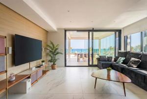 a living room with a couch and a tv at holaVivienda - Ático Boutique de Lujo en la Playa in Denia