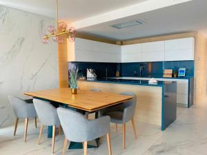 a kitchen with a wooden table and chairs at holaVivienda - Ático Boutique de Lujo en la Playa in Denia