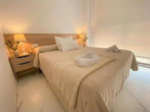 a bedroom with a bed with two towels on it at holaVivienda - Ático Boutique de Lujo en la Playa in Denia +14 photos