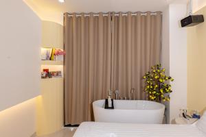 a bathroom with a bath tub in front of a shower at Ori Home in Ho Chi Minh City +92 photos