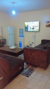 ein Wohnzimmer mit Sofa und Tisch in der Unterkunft Blossom's homes-Muthiga, one bedroom in Rungiri + 86 Fotos