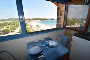 a table with a view of the beach through windows at Le Provence Plage in La Seyne-sur-Mer