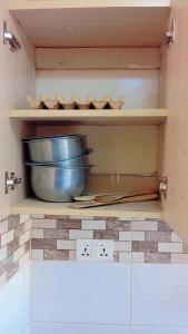 einem Küchenschrank mit einer Schale auf einem Regal in der Unterkunft Blossom's homes-Muthiga, one bedroom in Rungiri